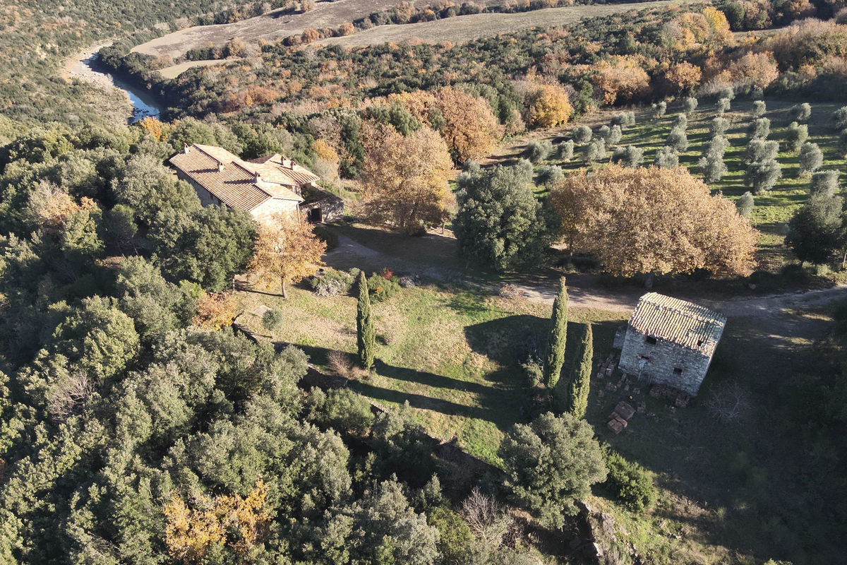 Aerial drone view of Tuscan farmhouse and barn in Val d'Orcia countryside